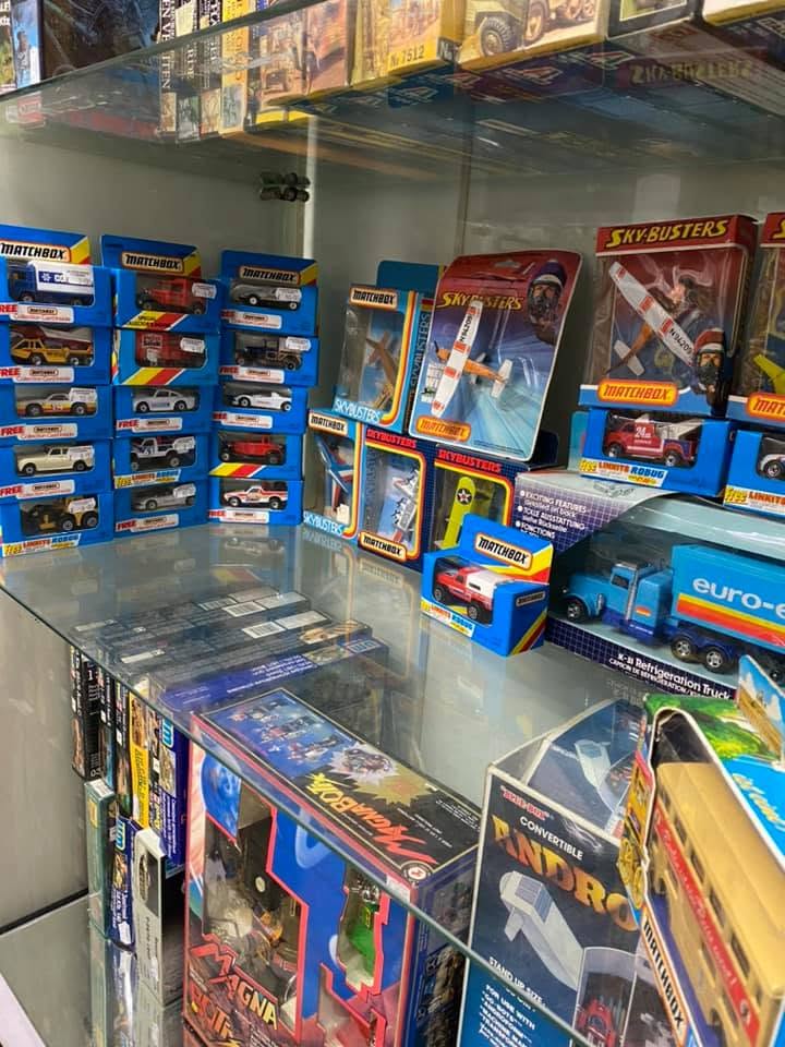 Vintage Matchbox and Sky-Busters diecast toys in glass cabinet